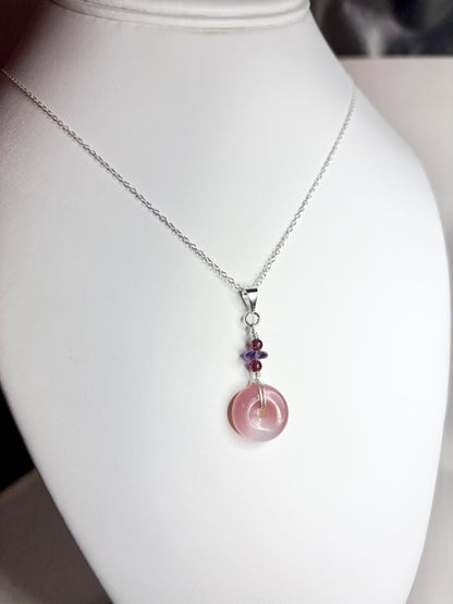 Sterling silver pendant necklace with a mauve-pink agate donut and amethyst and garnet beads.