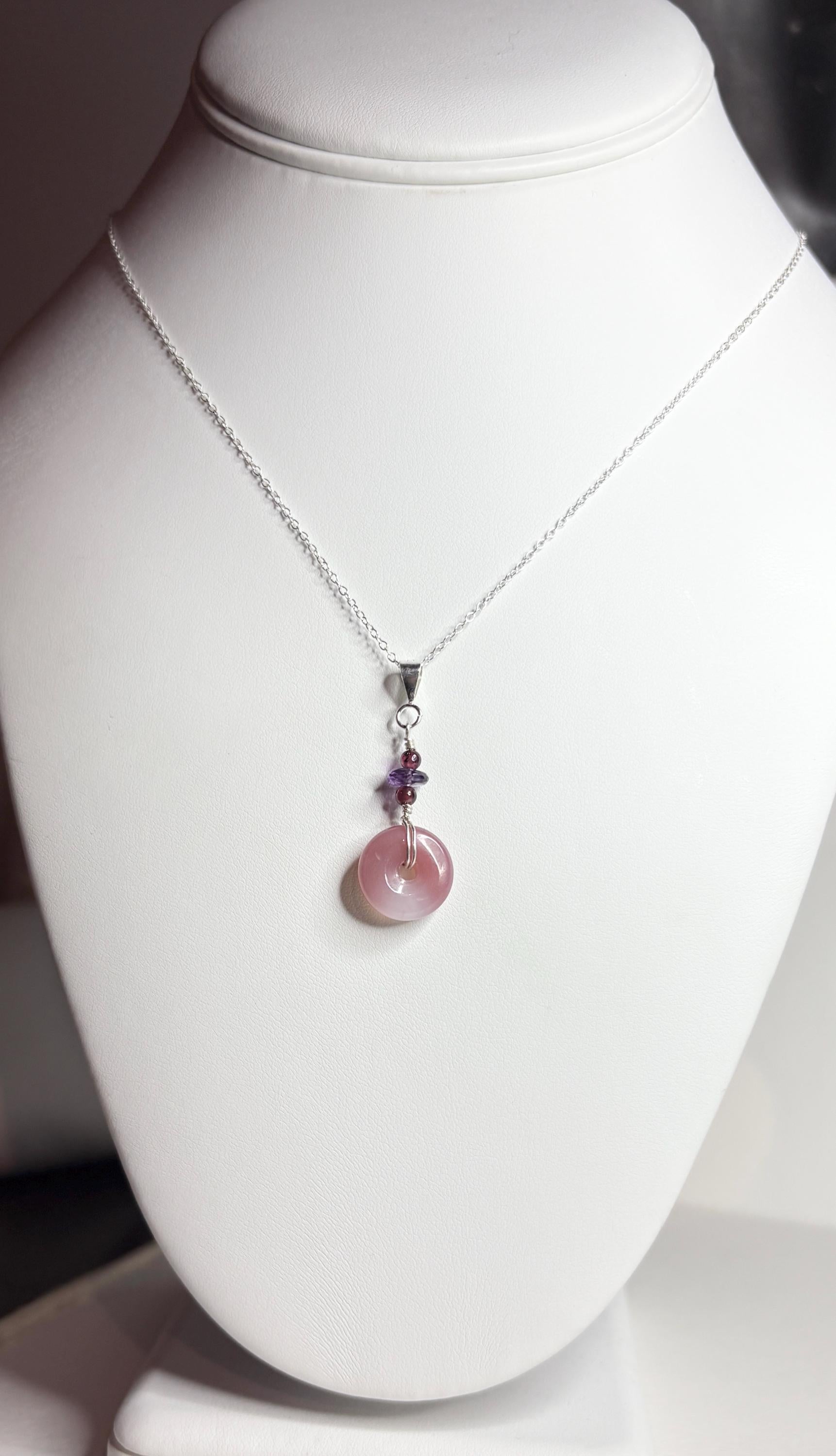 Untreated mauve-pink agate donut pendant with amethyst and garnet beads on an 18" sterling silver chain.