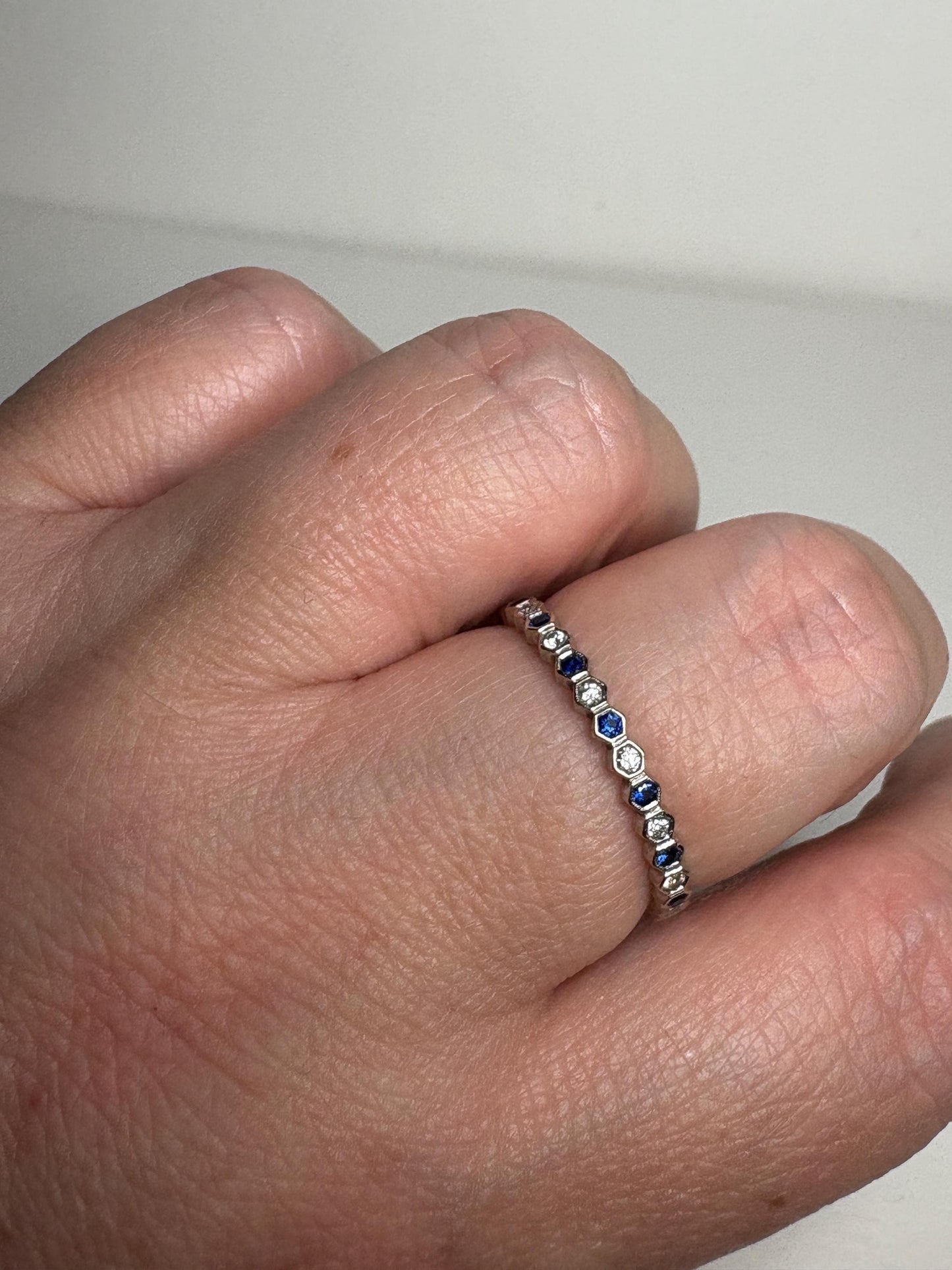 A 14k white gold band ring with alternating sapphires and diamonds.