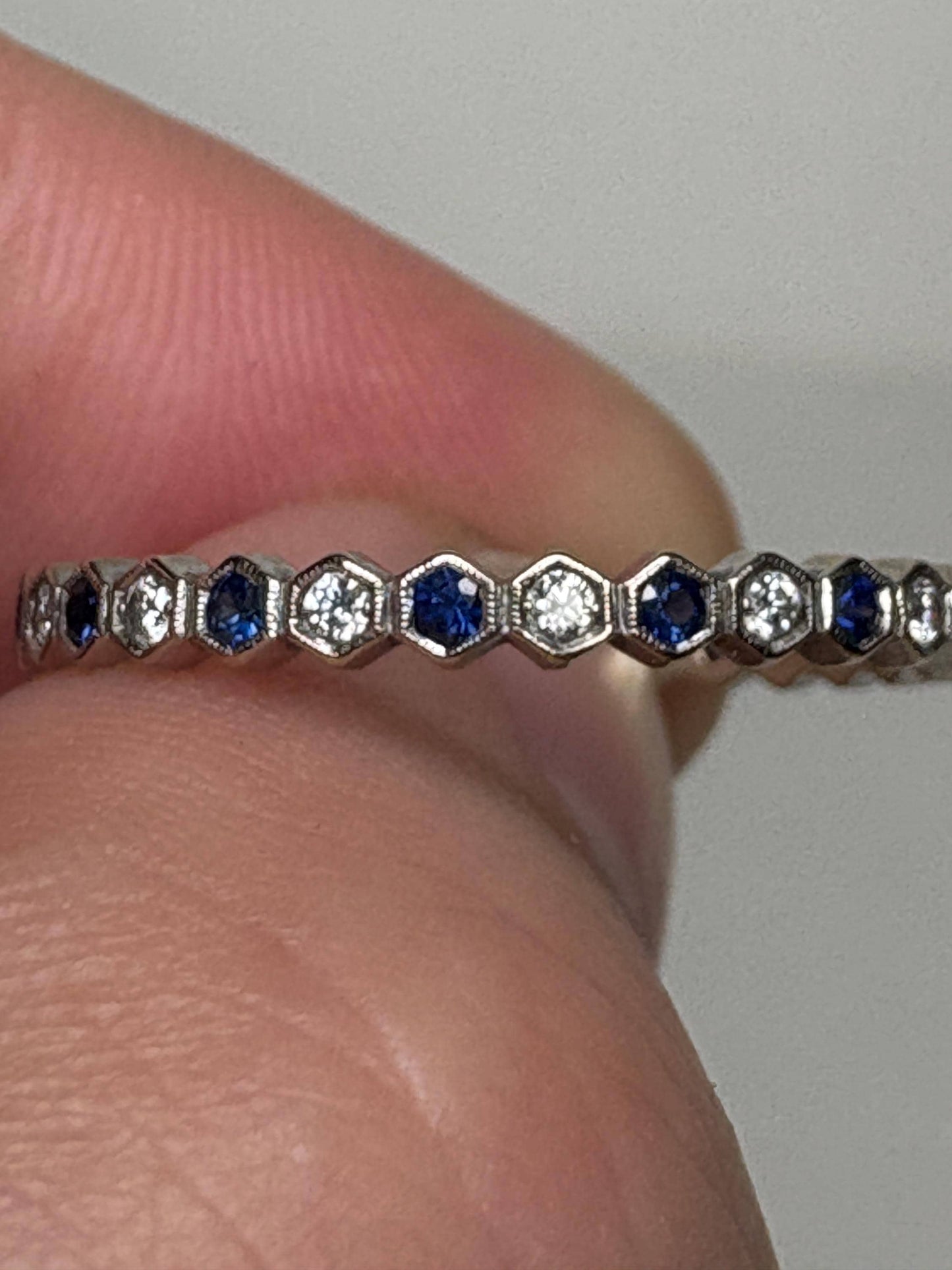 A white gold band ring with alternating blue sapphires and diamonds in a honeycomb hexagon pattern.