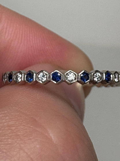 A white gold band ring with alternating blue sapphires and diamonds in a honeycomb hexagon pattern.