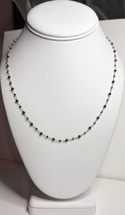 A delicate 14k gold necklace with small black diamond beads.