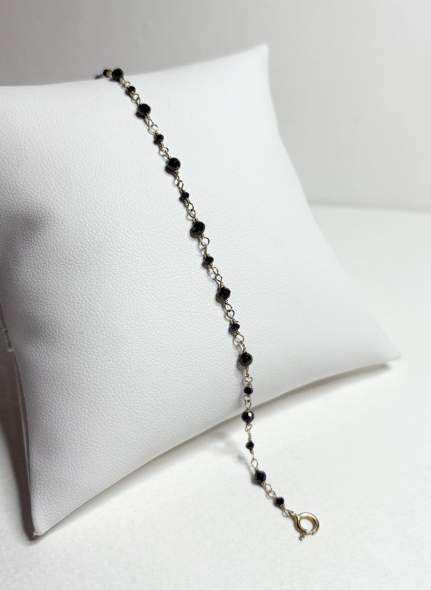 A 7-inch bracelet with black diamond beads and a 14k gold clasp.