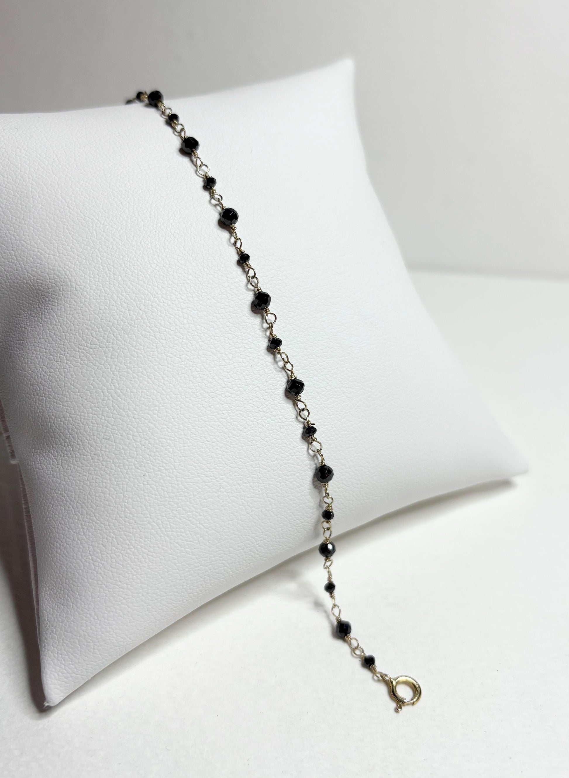 A 7-inch bracelet with black diamond beads and a 14k gold clasp.