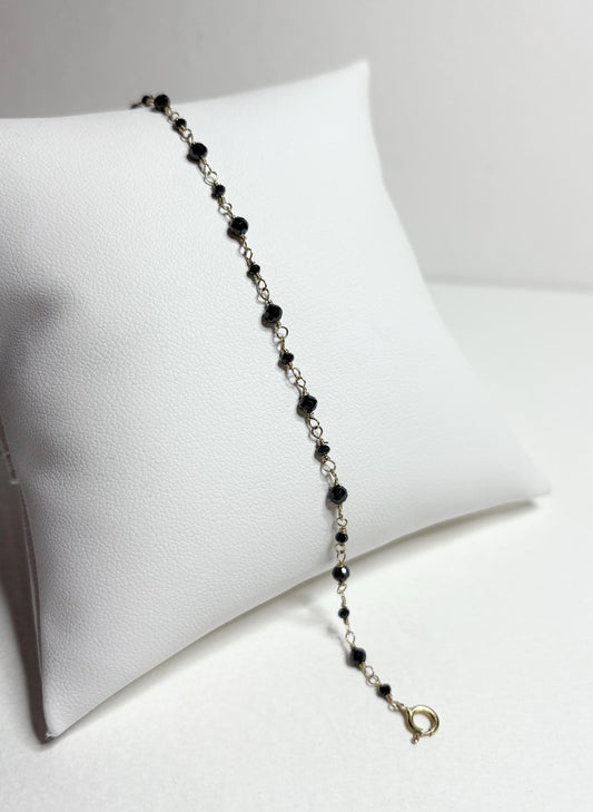 A 7-inch bracelet with black diamond beads and a 14k gold clasp.