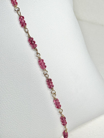 A delicate bracelet with small, faceted hot pink spinel beads and gold links.