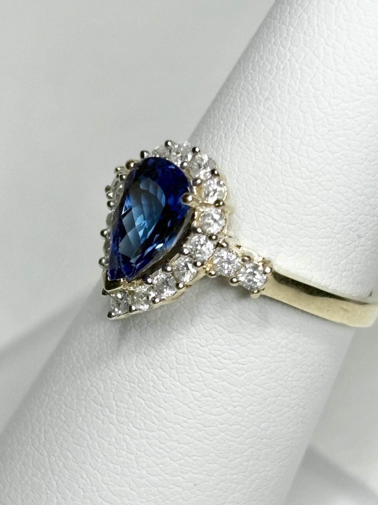 Pear tanzanite and diamond halo ring in 14k gold.