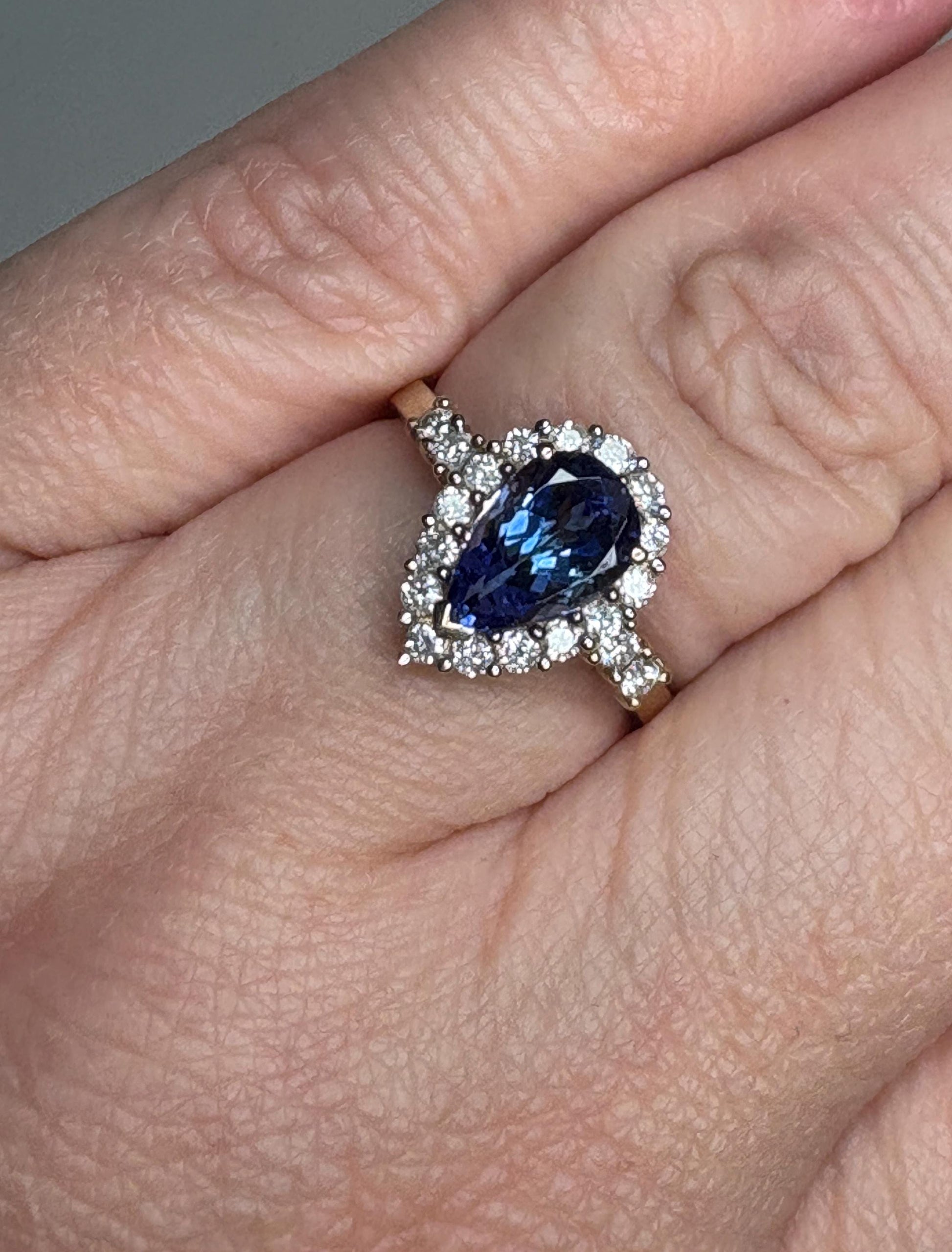 Pear tanzanite and diamond halo ring in 14k gold.