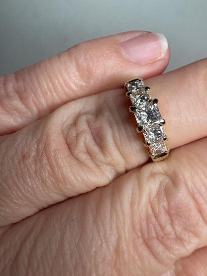 A 14k yellow gold anniversary band with five princess-cut diamonds.