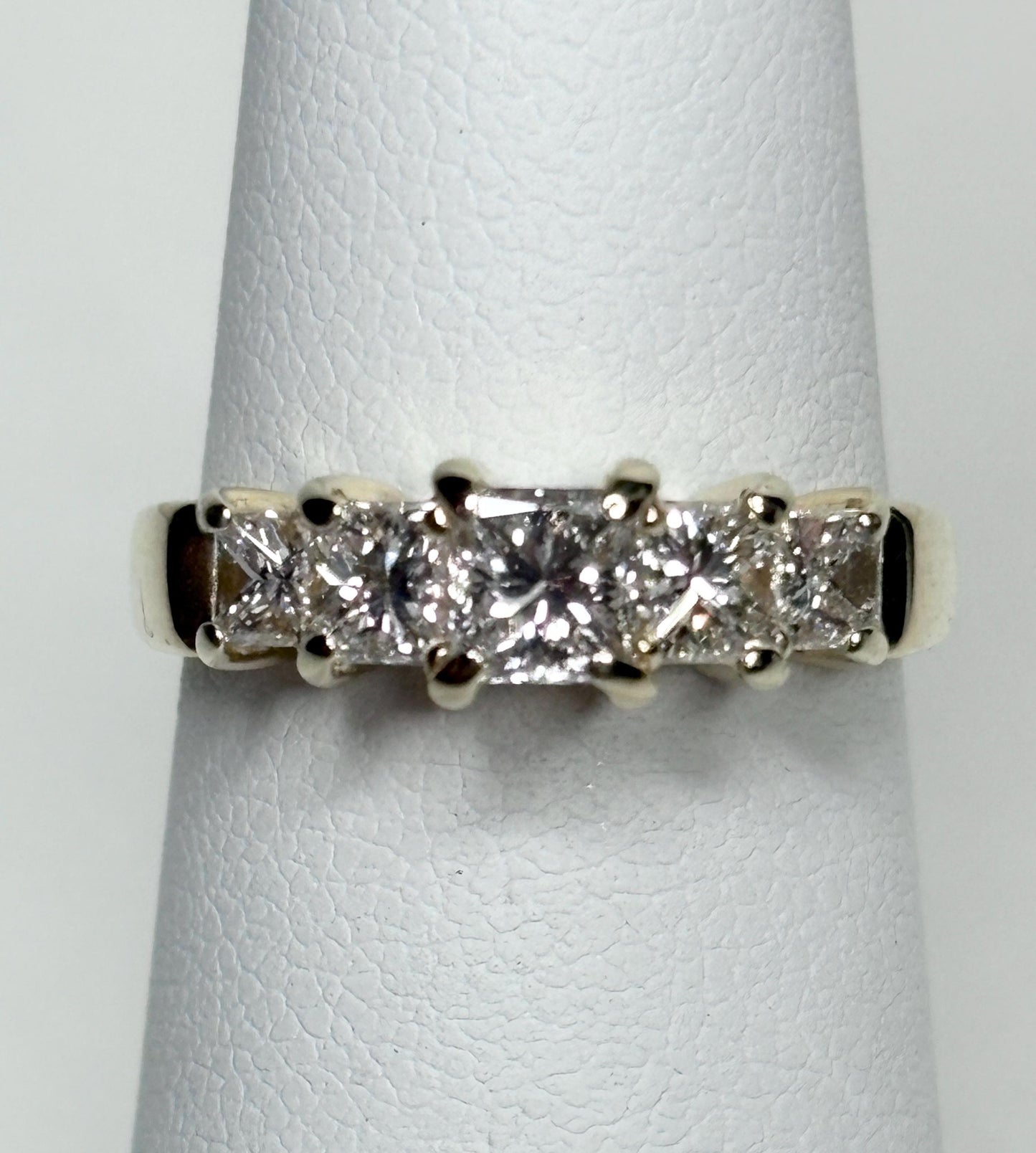 A 14k gold band ring with five princess-cut diamonds.