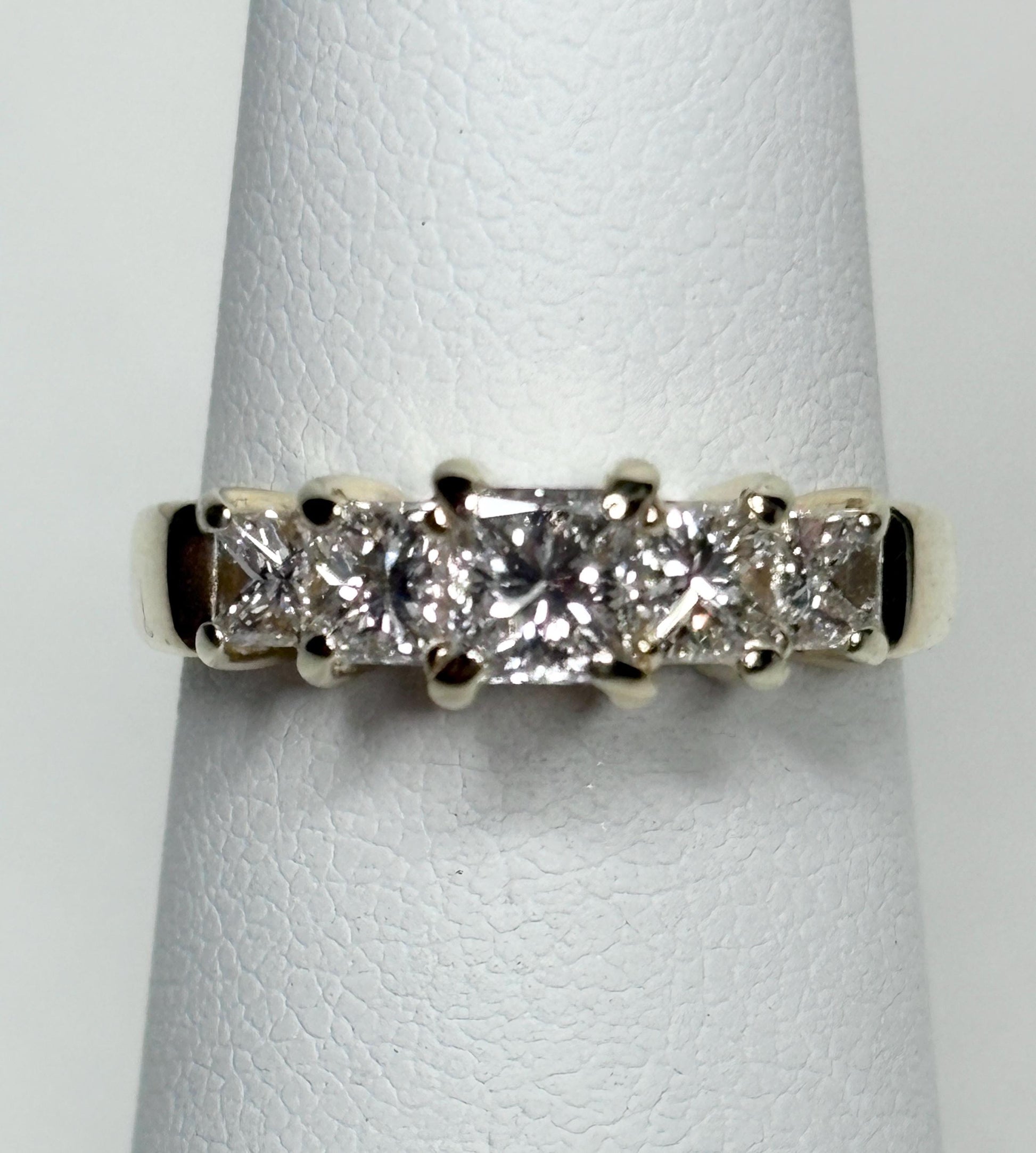 A 14k gold band ring with five princess-cut diamonds.