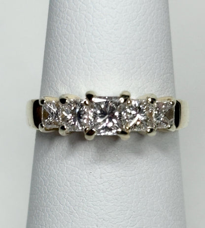A 14k gold band ring with five princess-cut diamonds.