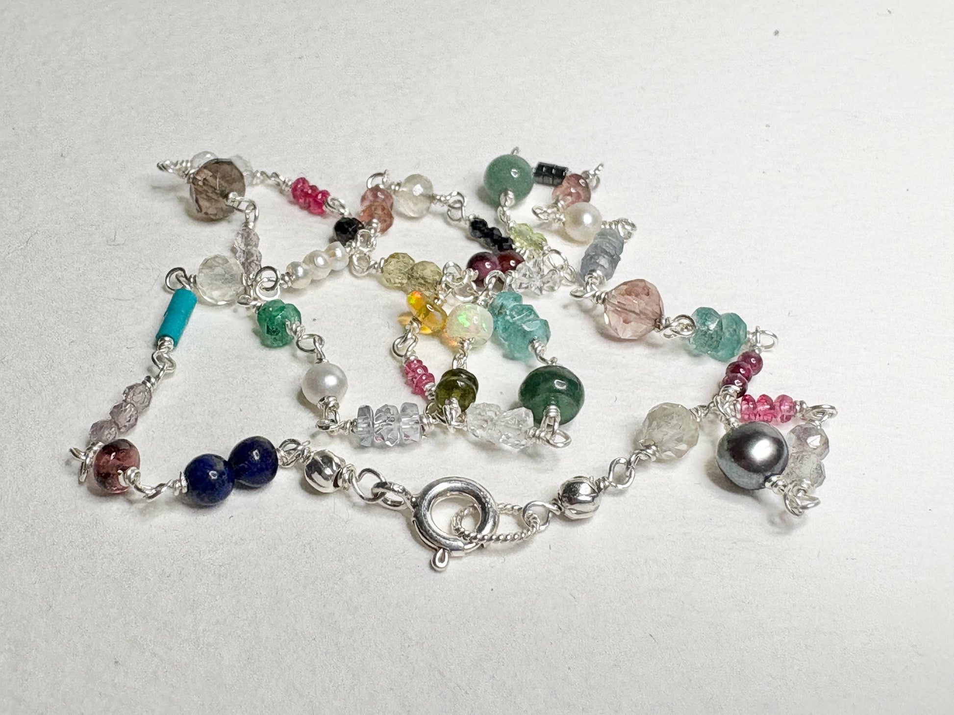 Sterling silver necklace with a variety of colorful natural gemstones.