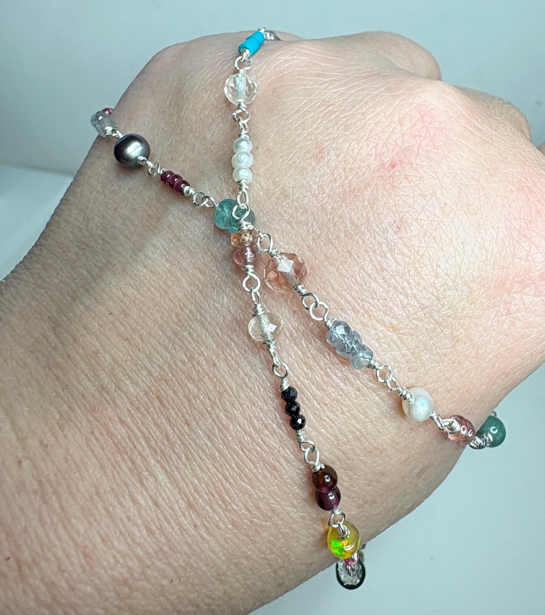 Sterling silver necklace with a variety of colorful gemstones and a black pearl.