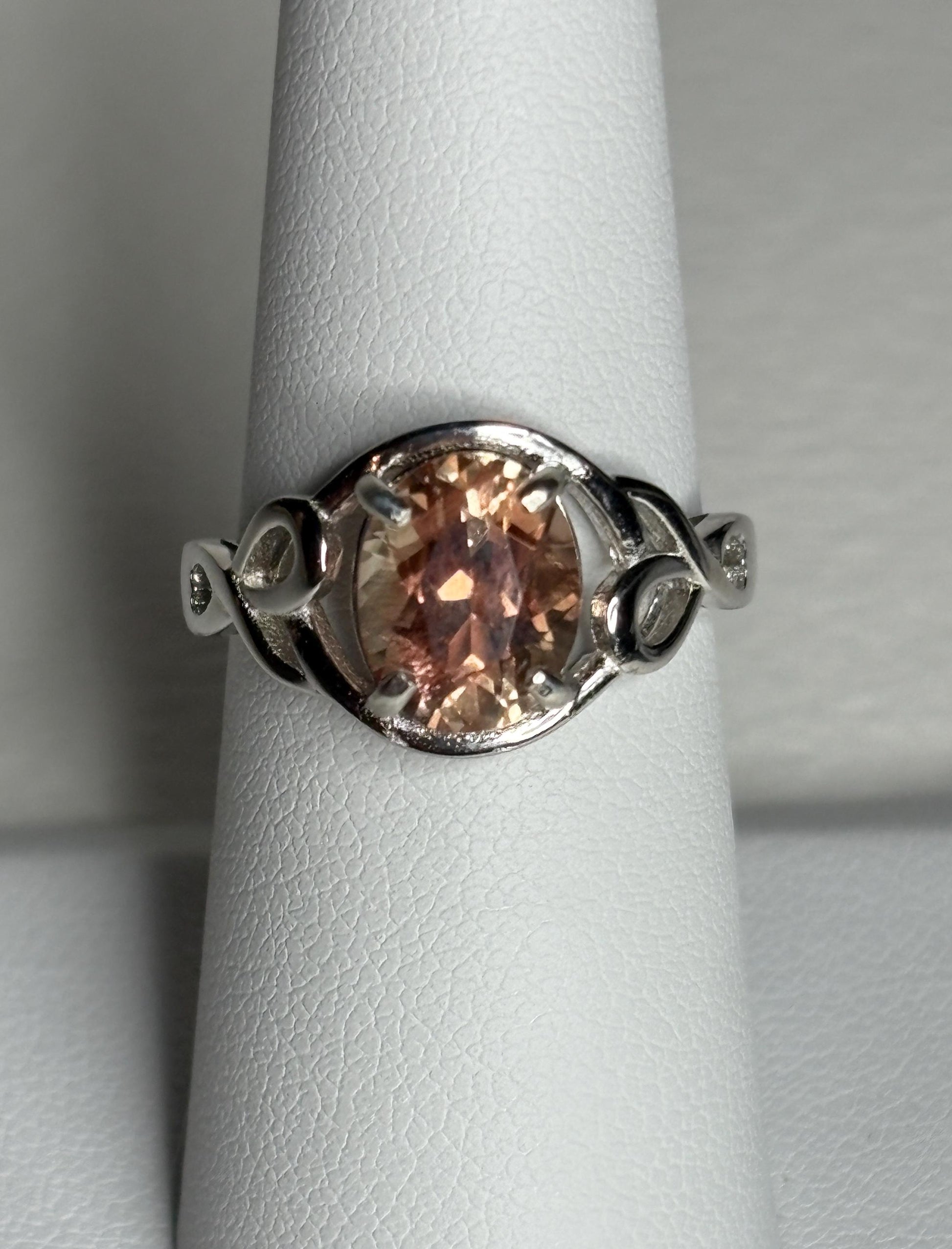 Sterling silver ring with an oval Oregon sunstone in a free-form ribbon setting.