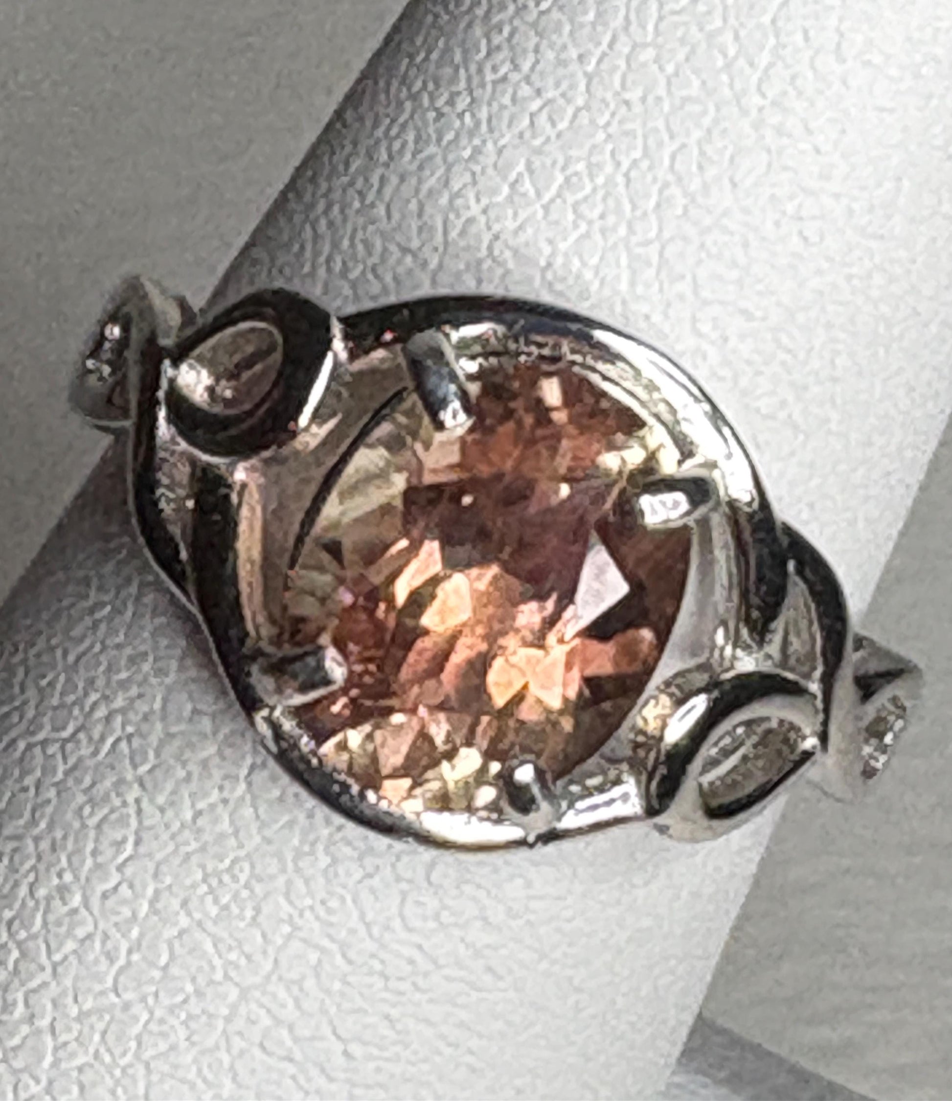 Sterling silver ring with an oval Oregon sunstone in a free-form ribbon setting.