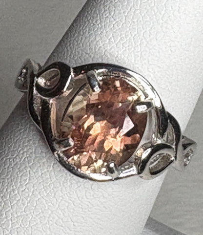 Sterling silver ring with an oval Oregon sunstone in a free-form ribbon setting.