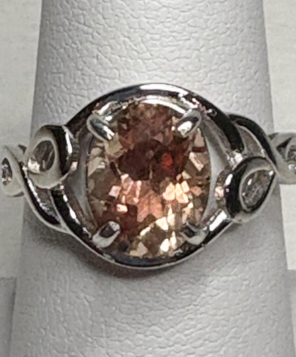 Sterling silver ring with an oval Oregon sunstone in a free-form ribbon setting.