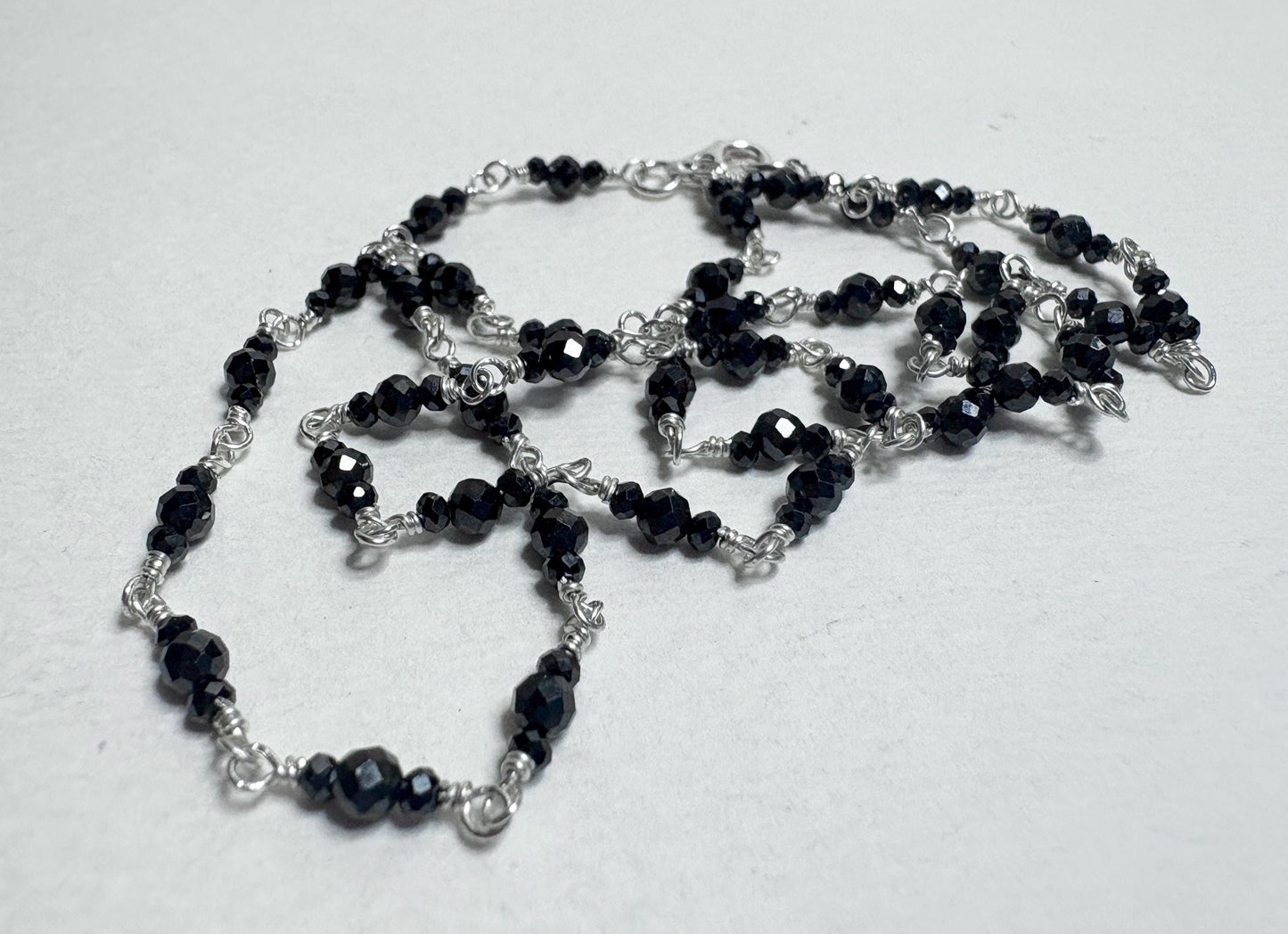 Sterling silver necklace with faceted black diamond beads.