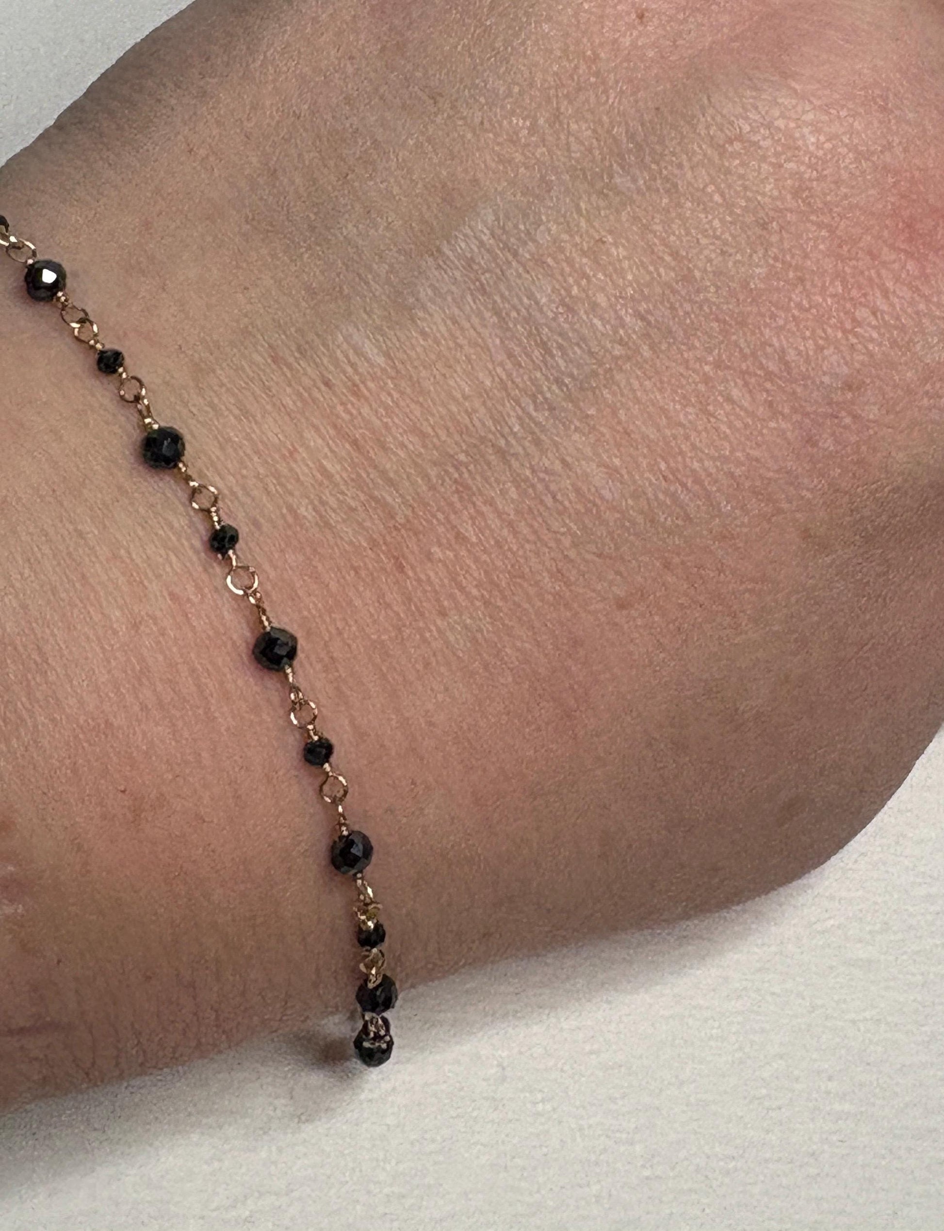 A 7-inch solid 14k gold bracelet with natural black diamond beads.