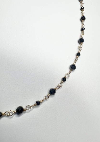 A delicate 14k gold bracelet with small faceted black diamond beads.