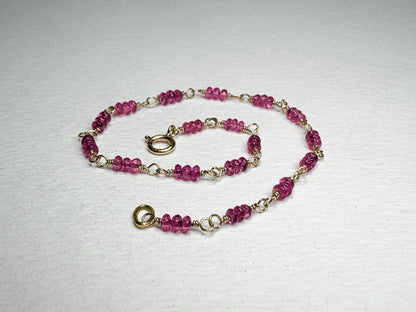 A delicate 14k gold bracelet with small, faceted hot pink spinel beads.