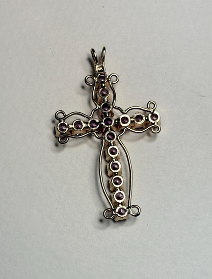 A 14k gold cross pendant with purple lab-created sapphires.