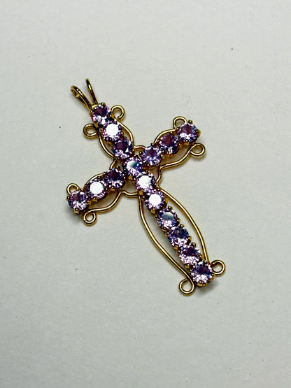 A 14k gold cross pendant necklace with purple lab-grown sapphires.
