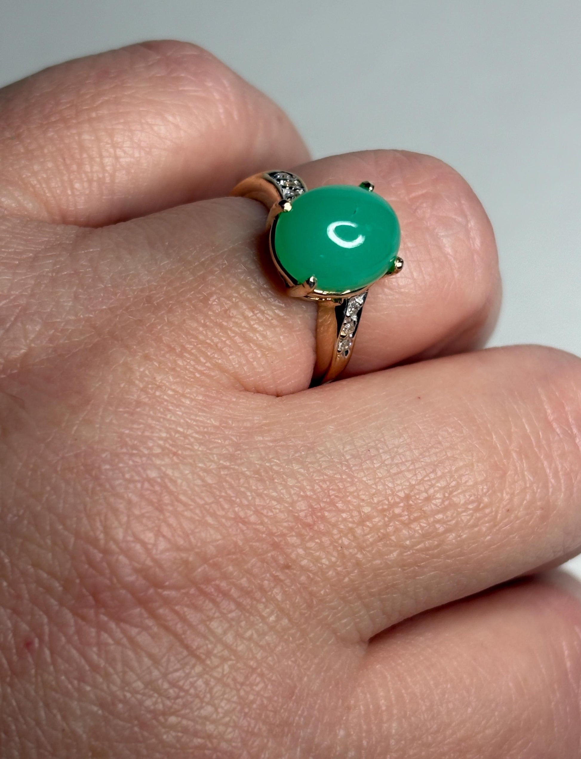 A 14k gold ring with a green chrysoprase stone and diamond accents.