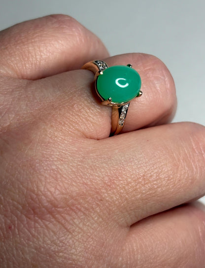 A 14k gold ring with a green chrysoprase stone and diamond accents.