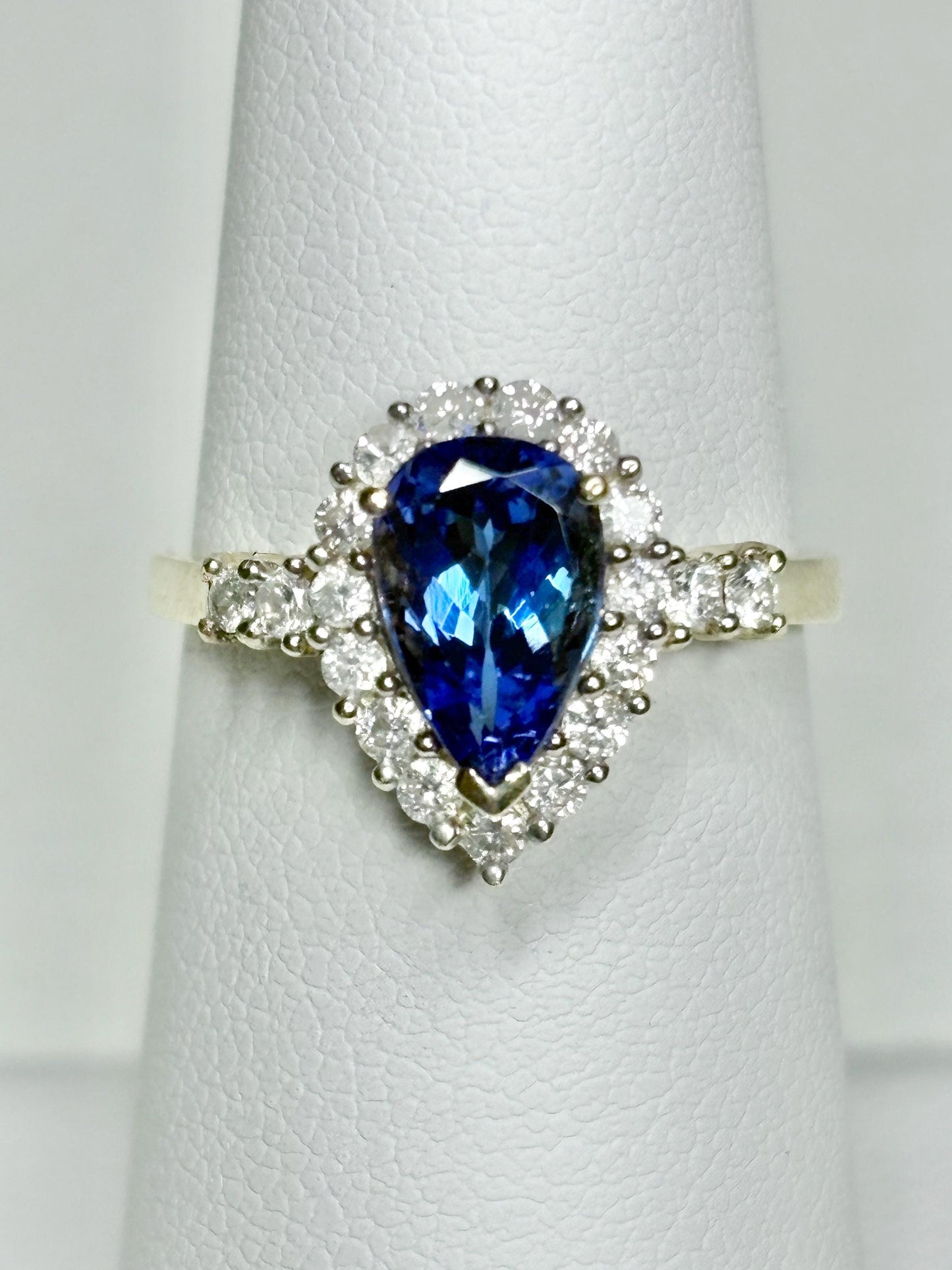 Pear tanzanite and diamond halo ring in 14k gold.