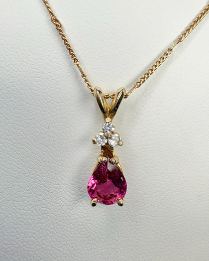 Gold necklace with a pear-shaped rubellite tourmaline pendant and diamond accents.