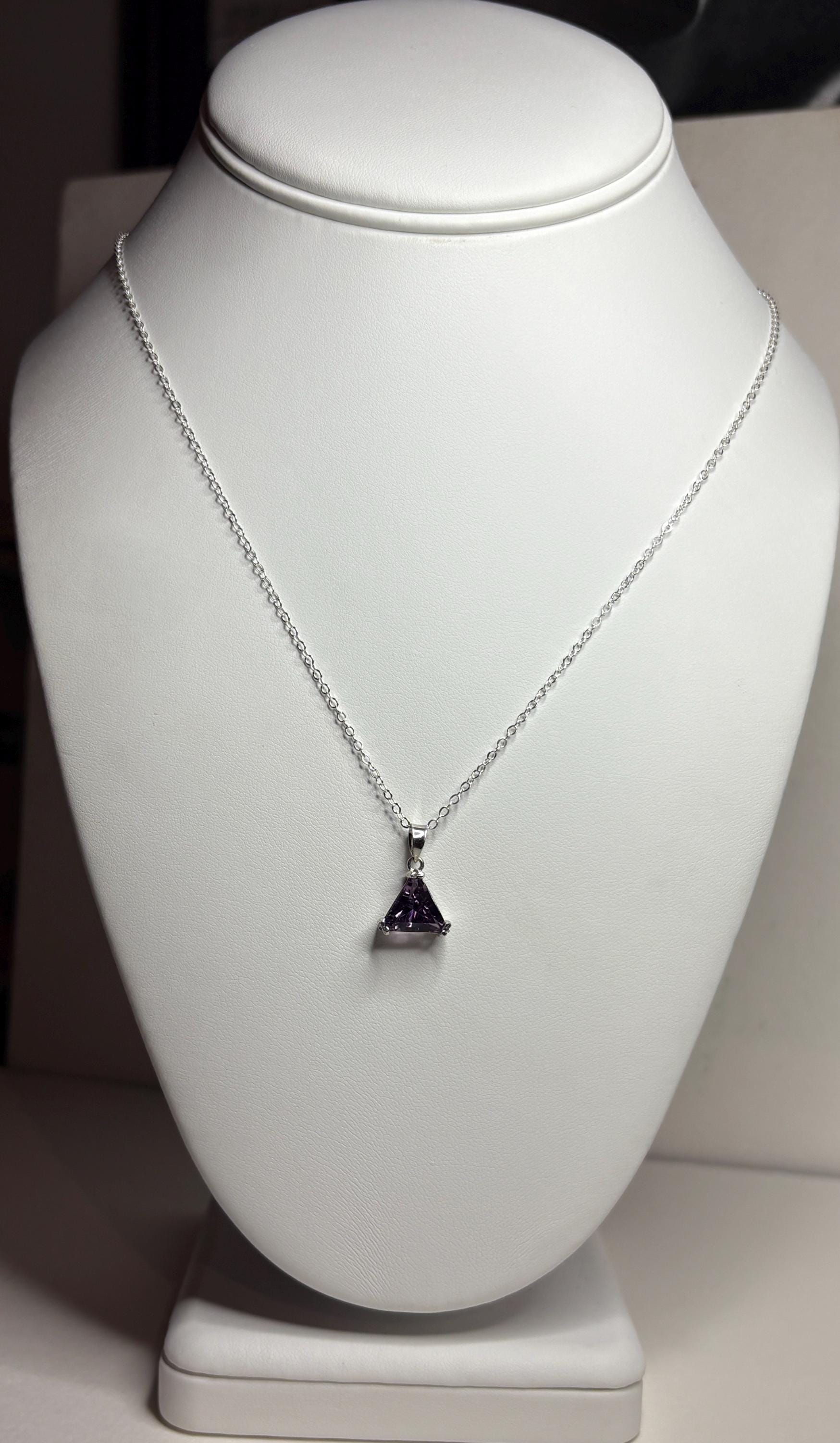 Sterling silver necklace with a triangular amethyst pendant.