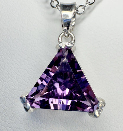 Sterling silver pendant necklace with a triangular amethyst gemstone.