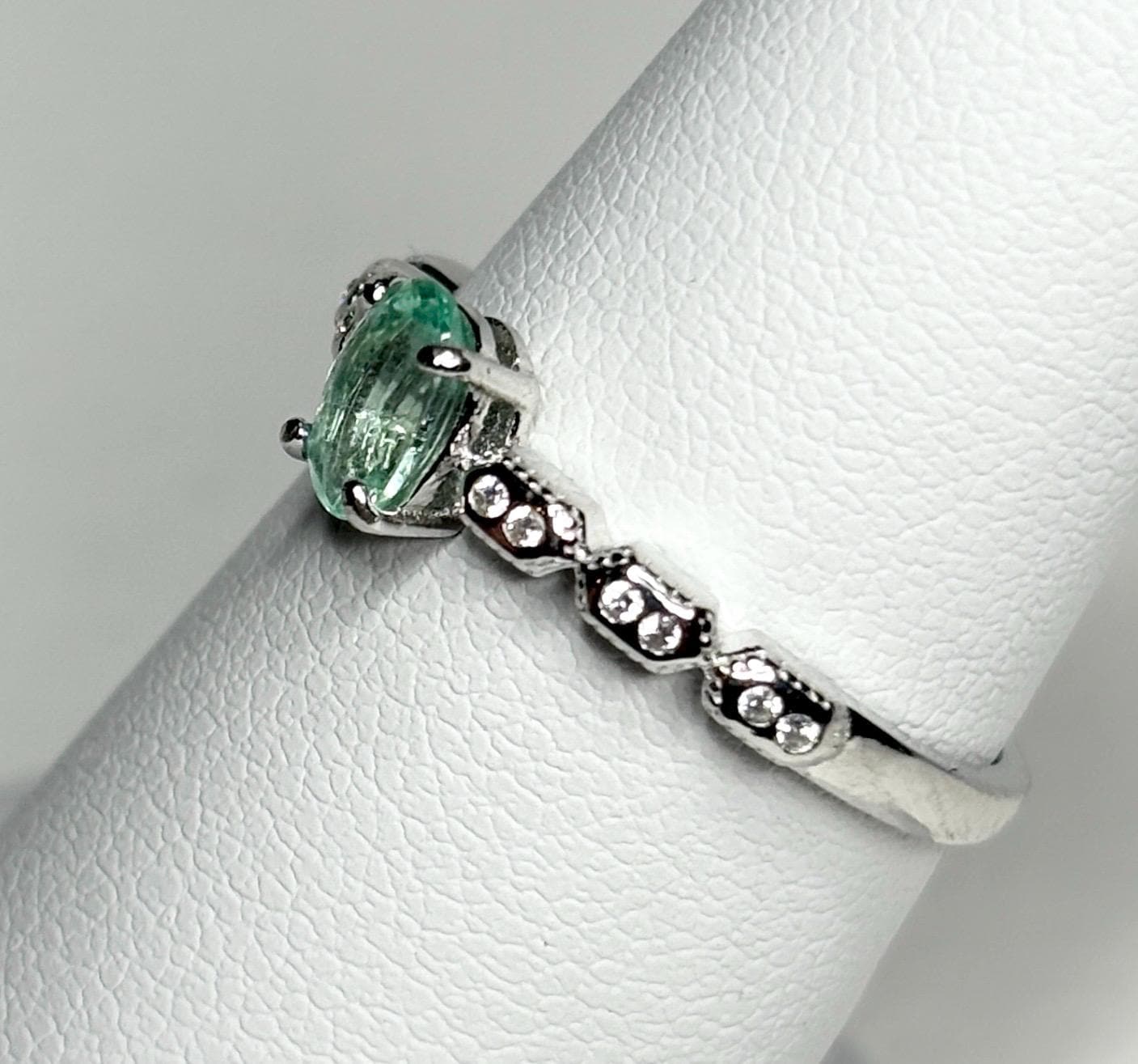 Sterling silver ring with an oval mint green tourmaline and small crystal accents.
