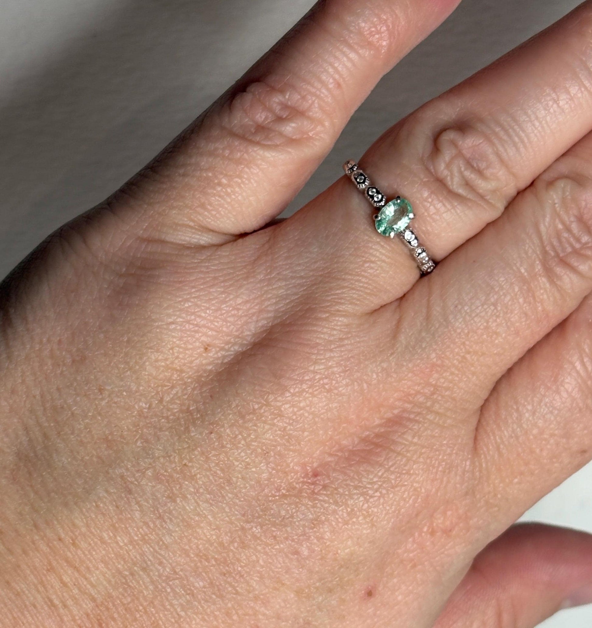 Sterling silver ring with a mint green oval tourmaline and crystal accents.
