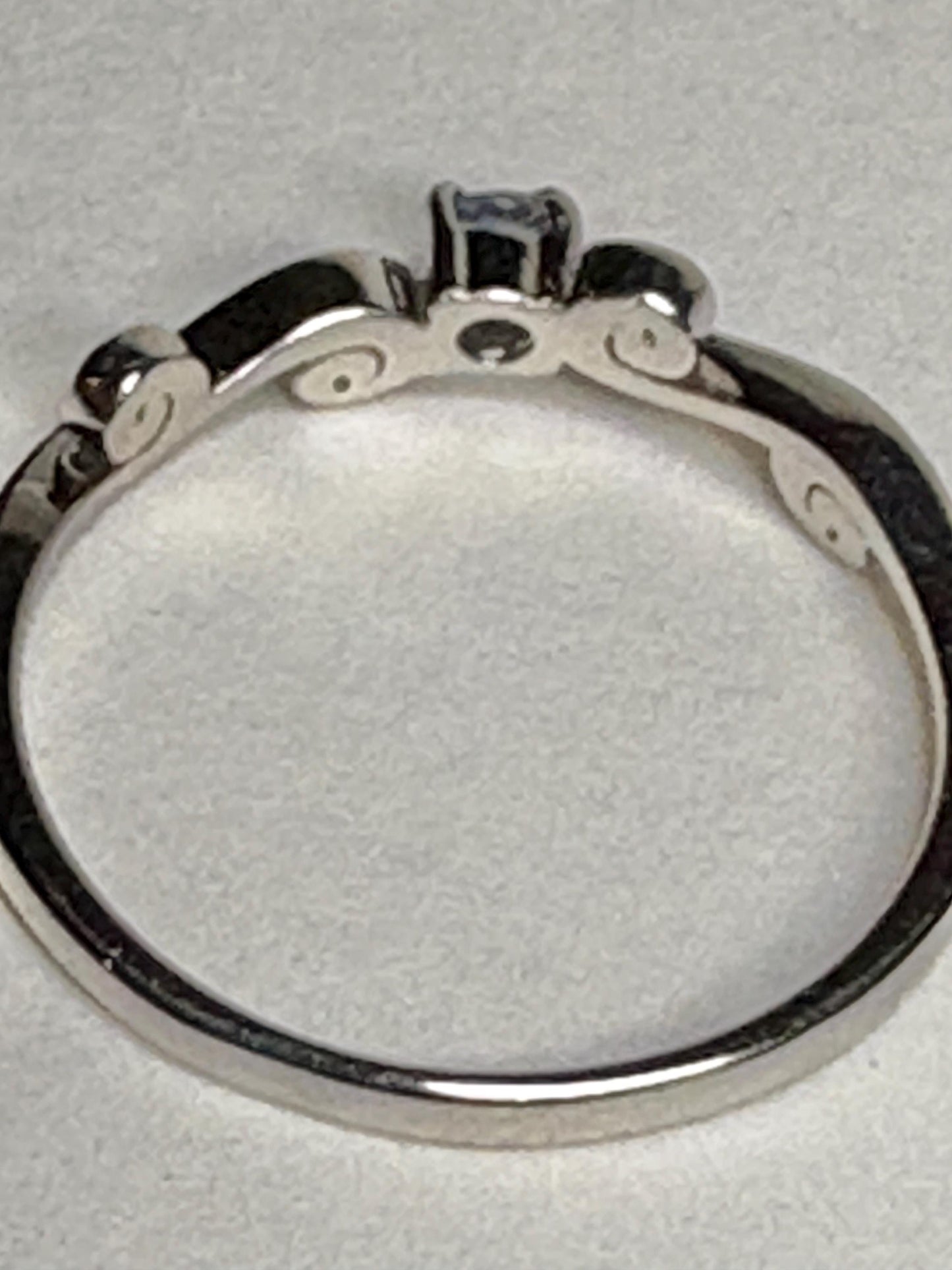 Sterling silver ring with a light blue sapphire and swirl band.