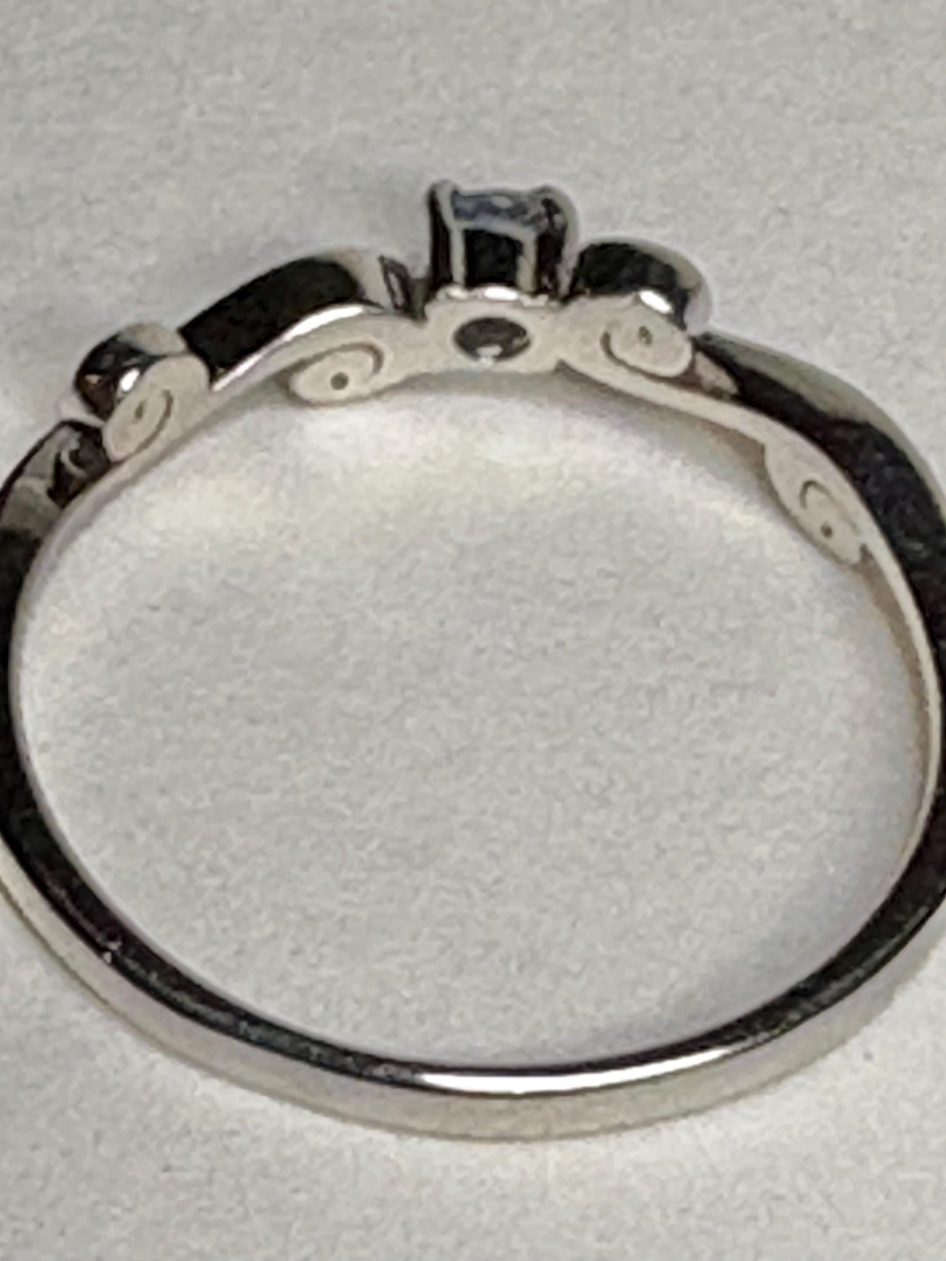 Sterling silver ring with a light blue sapphire and swirl band.