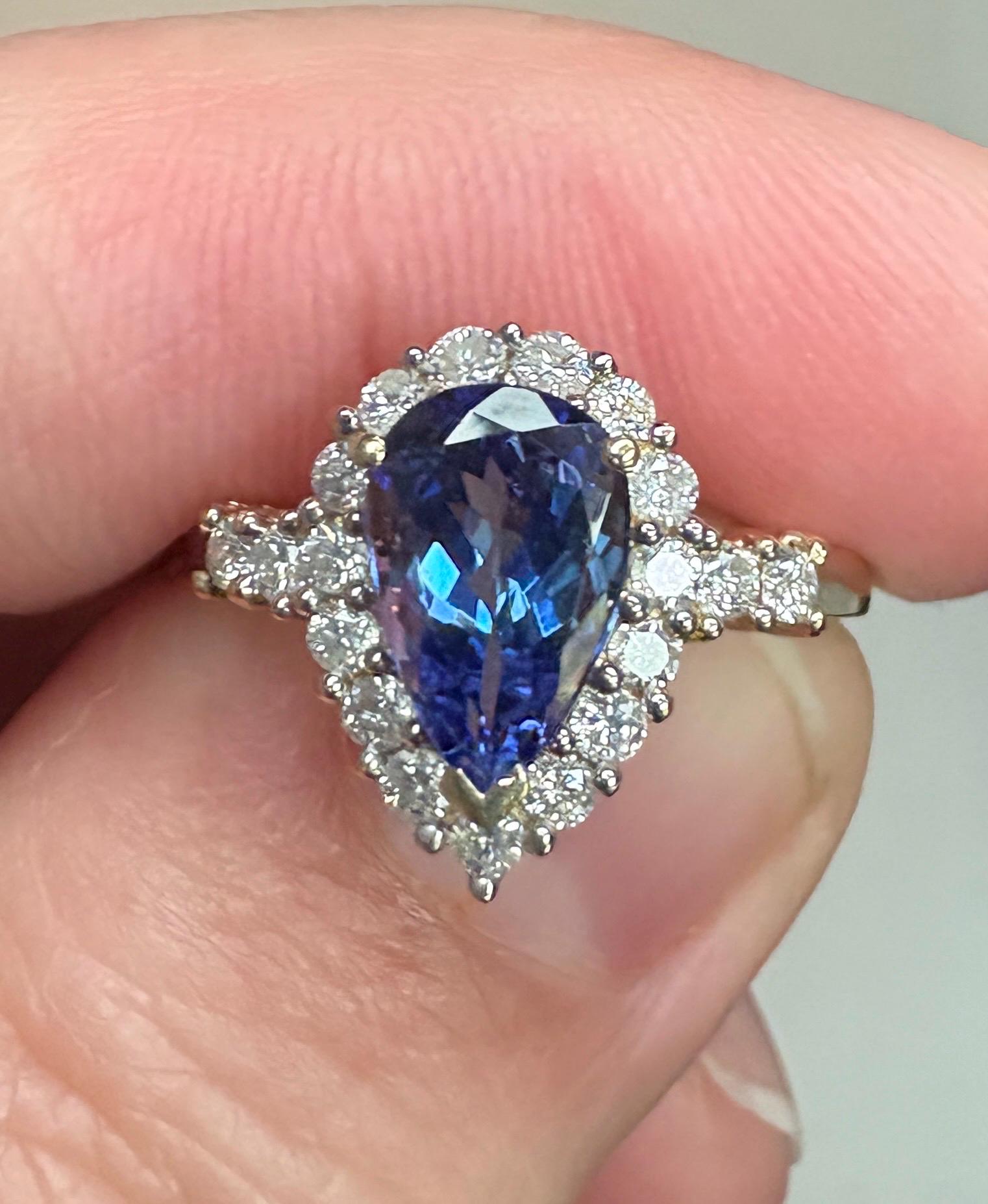 Pear-shaped tanzanite ring with a diamond halo in 14k gold.
