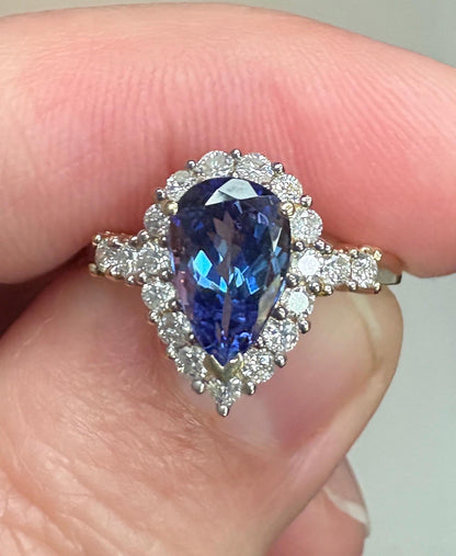 Pear-shaped tanzanite ring with a diamond halo in 14k gold.