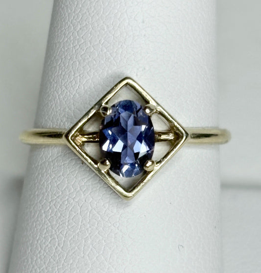 A 10k gold ring with a geometric setting holding an oval iolite.