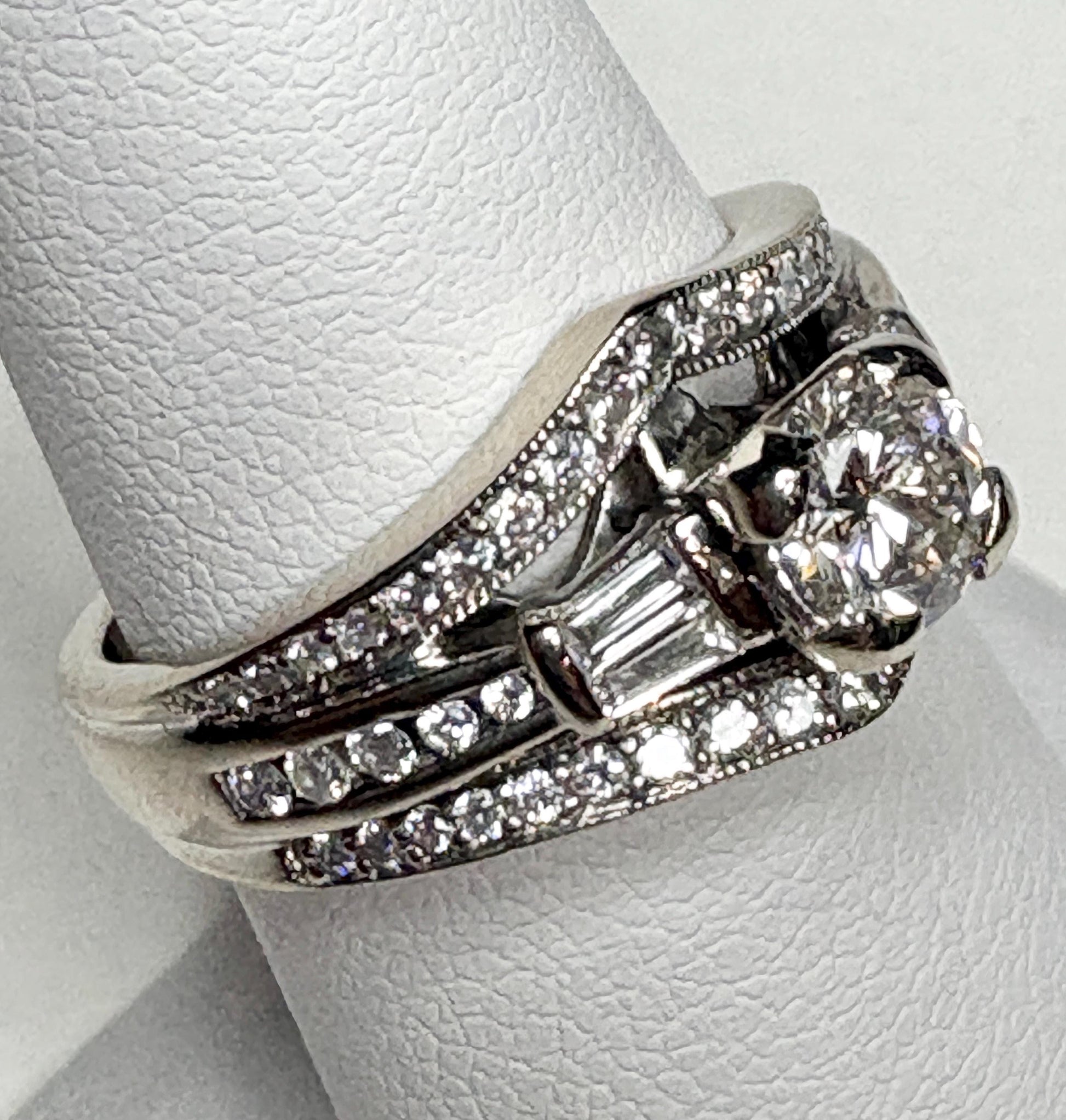 14k white gold ring with a central diamond and baguette and round accent diamonds.