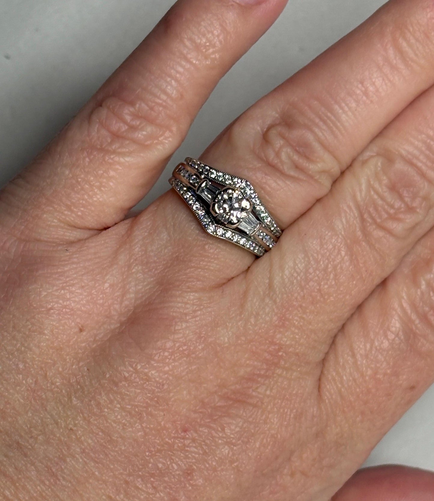Three stacked 14k white gold rings with round and baguette diamonds.