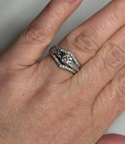 Three stacked 14k white gold rings with round and baguette diamonds.