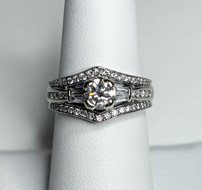 A 14k white gold engagement ring set with a round center diamond and baguette and round accent diamonds.