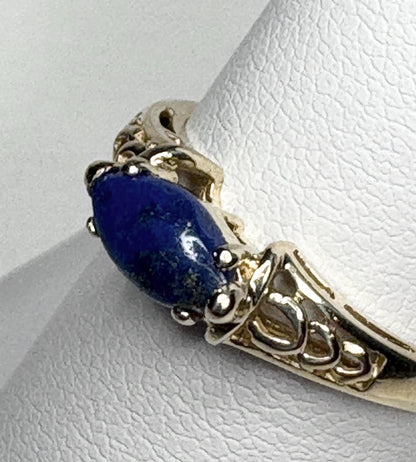 A 14k gold ring with an east-west set marquise lapis lazuli cabochon.