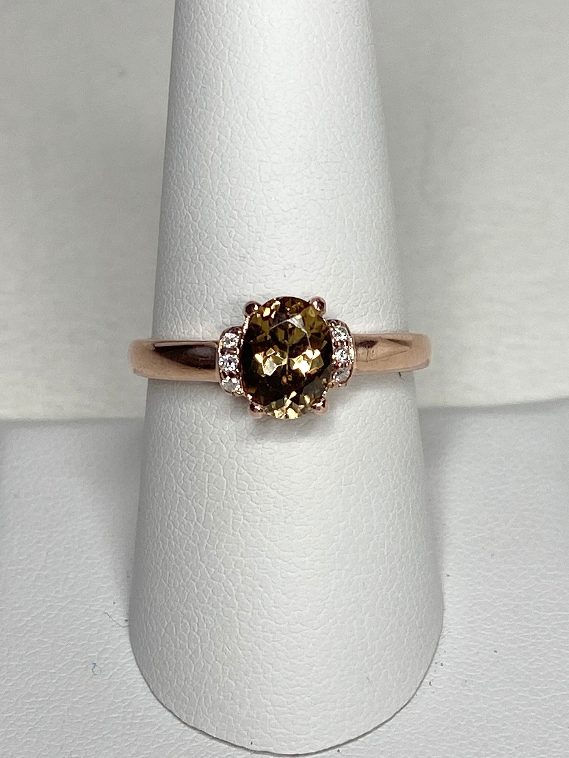 Oval green-gold zircon and diamond ring in rose gold.