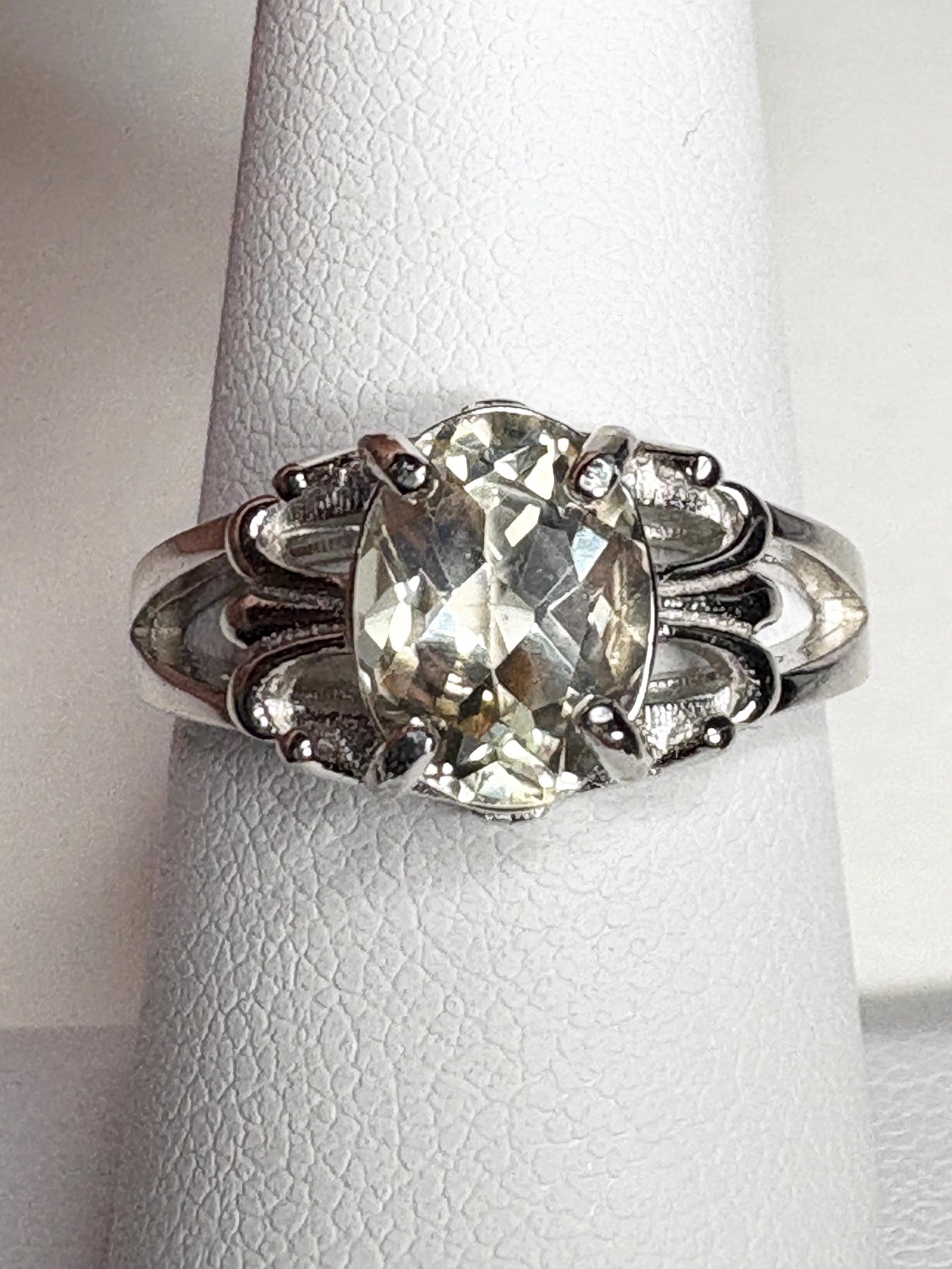 Sterling silver ring with an oval yellow Oregon sunstone and fleur de lis accents.