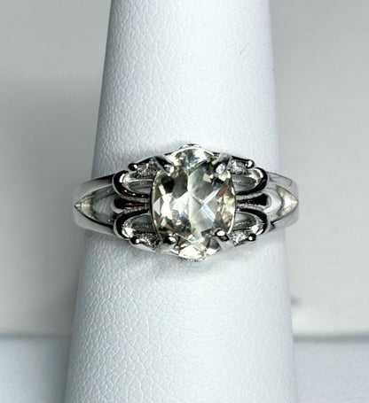 Sterling silver ring with an oval yellow sunstone and fleur de lis accents.