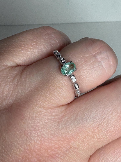 Sterling silver ring with a mint green oval tourmaline and crystal accents.